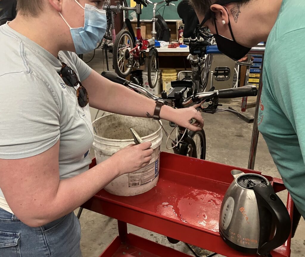 two people close up working on bikes